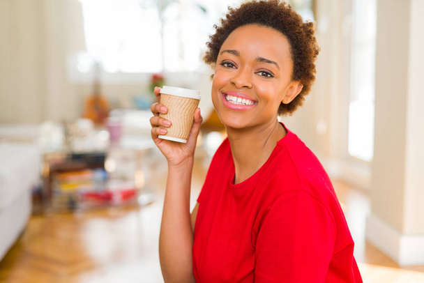 Beautiful young african american woman drinking a coffee in a ta - 写真・画像