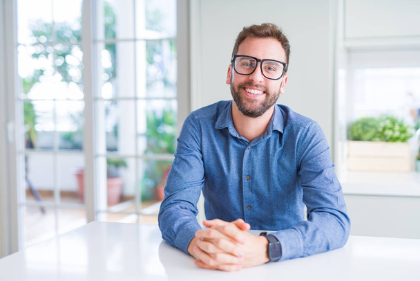 Handsome man wearing glasses and smiling relaxed at camera - 写真・画像