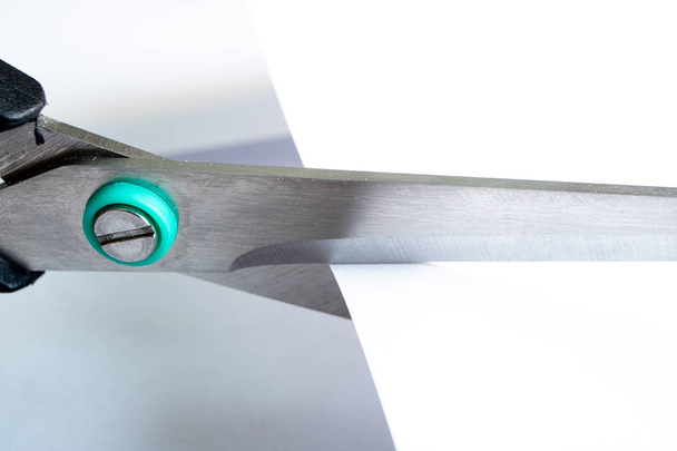 крупным планом ножницы, которые режут белую бумагу, образуют линию
 - Фото, изображение