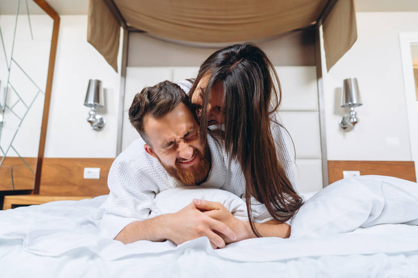 Imagen mostrando pareja feliz descansando en habitación de hotel
 - Foto, Imagen
