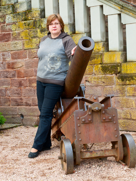 Donna di mezza età vicino a un vecchio cannone
 - Foto, immagini