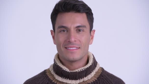Face of young happy Hispanic man smiling ready for winter - Imágenes, Vídeo