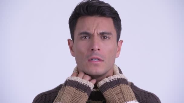 Face of young Hispanic man feeling cold for winter - Felvétel, videó