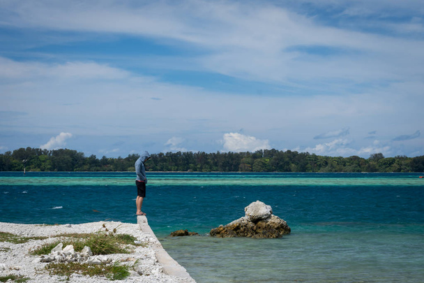 Мужчина стоит один на краю пляжа на острове Харапан, Индонезия. Мужчина грустит и просто стоит и наслаждается моментом.
 - Фото, изображение