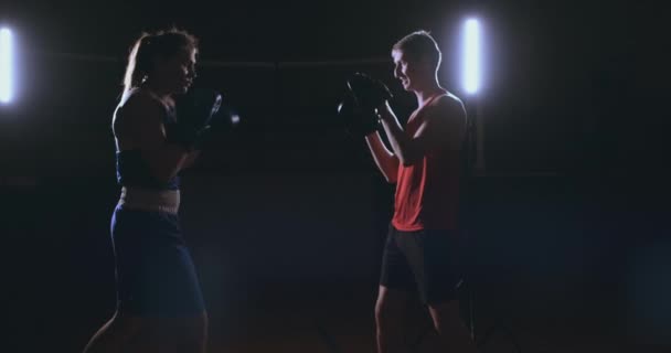 Mujer golpea los guantes de enfoque en el gimnasio de boxeo
 - Metraje, vídeo