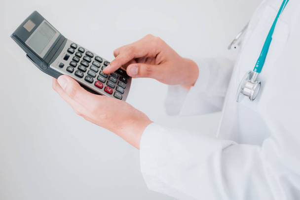 Close-up do médico fêmea está calculando o custo da medicina no hospital do escritório, médico fêmea está usando a calculadora. Saúde e Conceito Financeiro
. - Foto, Imagem