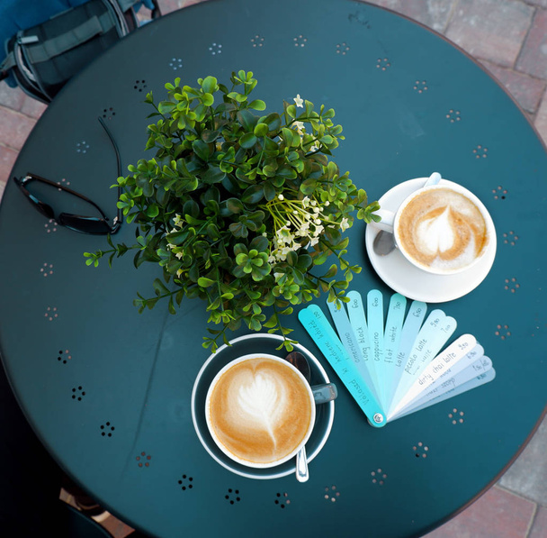меню блакитних дощок з різними назвами напоїв і чашками кави на синьому столі
 - Фото, зображення