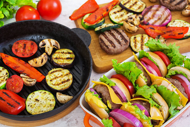 Gegrilde groenten en handgemaakte hamburger. Courgette, aubergine, champignons, peper op de grill. Bovenaanzicht - Foto, afbeelding