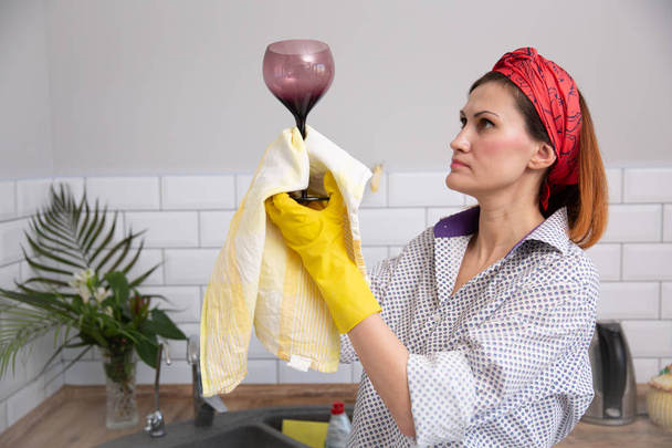 Vrouw reiniging of ruges glas in de keuken. - Foto, afbeelding