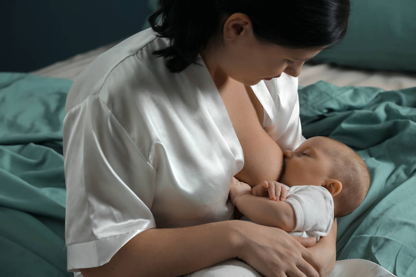 Jovem mulher amamentando seu bebê em casa - Foto, Imagem