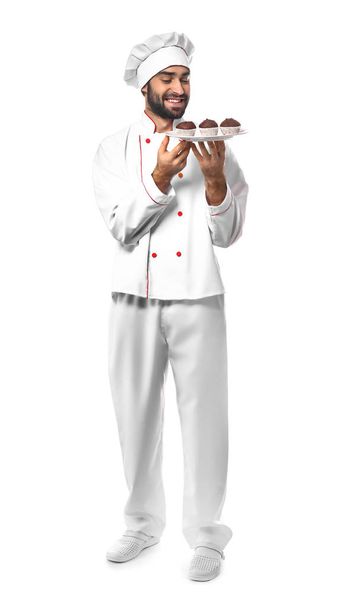 Confeiteiro masculino com sobremesa saborosa no fundo branco
 - Foto, Imagem