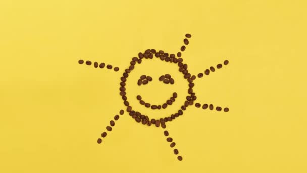 Divertido y lindo sol de granos de café sobre un fondo amarillo. Simboliza la alegría y el despertar en la mañana
. - Imágenes, Vídeo