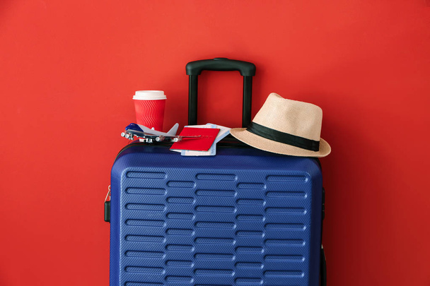 Συσκευασμένη βαλίτσα σε έγχρωμο φόντο. Ταξιδιωτική έννοια - Φωτογραφία, εικόνα