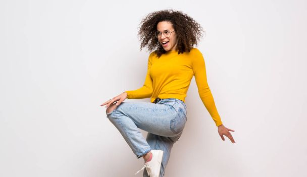 Dominican woman with curly hair jumping over isolated white back - Photo, Image