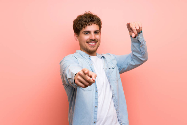 Blonder Mann über rosa Wand zeigt lächelnd mit dem Finger auf dich - Foto, Bild