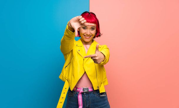 Nuori nainen, jolla on keltainen takki. Kehyssymboli
 - Valokuva, kuva