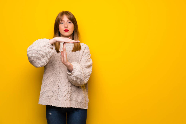 Redhead woman over yellow wall making time out gesture - Foto, Imagem