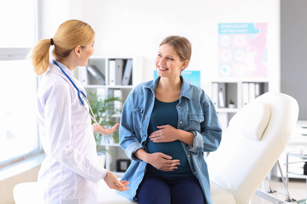 Νεαρή έγκυος γυναίκα επισκέπτεται τον γυναικολόγο της στην κλινική - Φωτογραφία, εικόνα