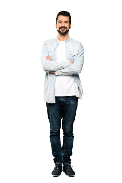Full-length shot of Handsome man with beard keeping the arms crossed in frontal position over isolated white background - Foto, Bild