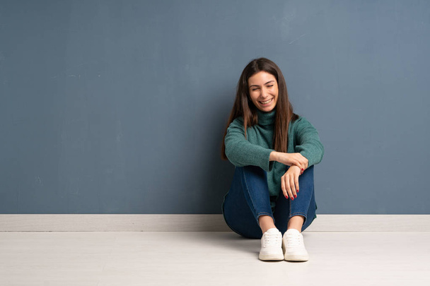 Young woman sitting on the floor smiling a lot - Foto, Imagen
