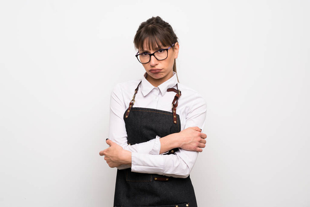 Young woman with apron with sad and depressed expression - Photo, Image