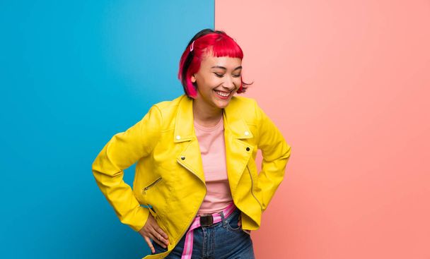 Young woman with yellow jacket happy and smiling - 写真・画像
