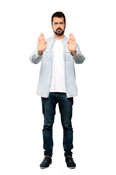 Повнометражний знімок красивого чоловіка з бородою робить стоп жест і розчарований над ізольованим білим тлом
 - Фото, зображення