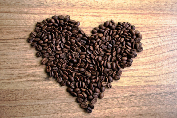 Serce się z ziaren kawy na drewnianym stole - Zdjęcie, obraz