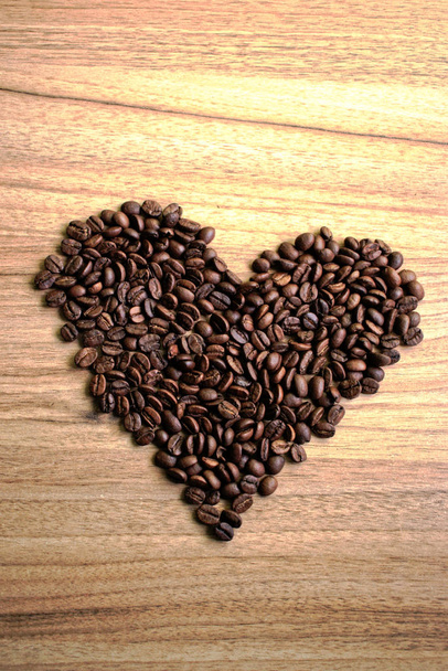 Сердце из кофейных зерен на деревянном столе
 - Фото, изображение