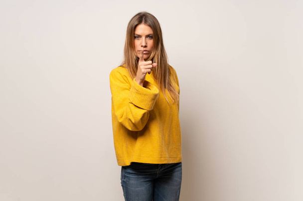 Mujer con suéter amarillo sobre pared aislada frustrado y apuntando hacia el frente
 - Foto, Imagen