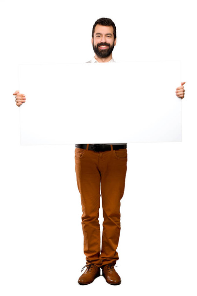 Feliz hombre guapo con barba sosteniendo un cartel vacío
 - Foto, imagen
