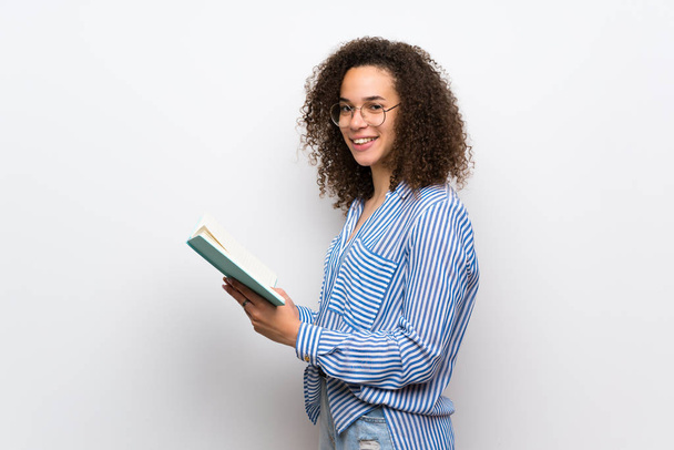 Femme dominicaine avec chemise rayée tenant un livre et appréciant la lecture
 - Photo, image