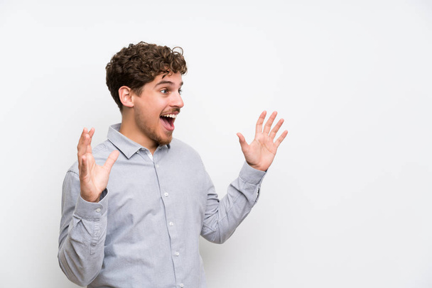 Blonde man over isolated white wall with surprise facial expression - Foto, Imagen