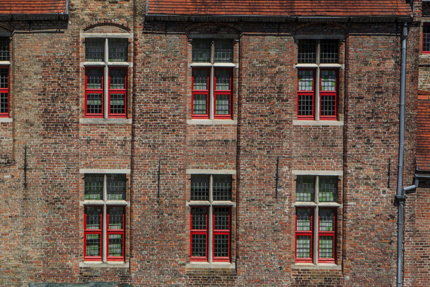 Red brick house facade with windows in Bruges, Belgium - Фото, изображение