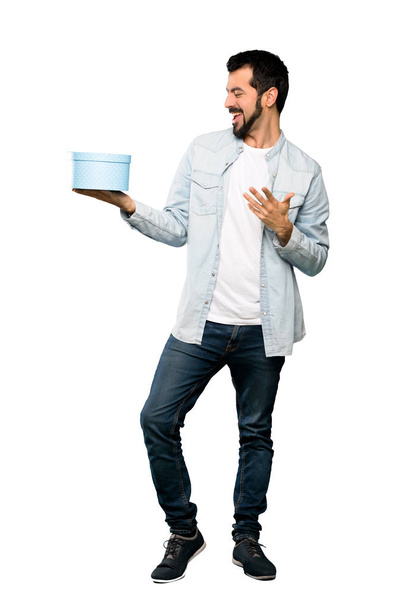 Handsome man with beard holding a gift - Foto, Imagen