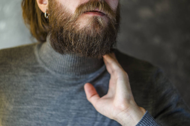 Man in Gray Sweater Holds His Hand by the Throat. - Φωτογραφία, εικόνα