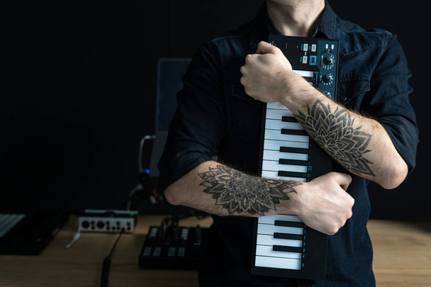 Man holding piano keyboard in his hands - Фото, зображення