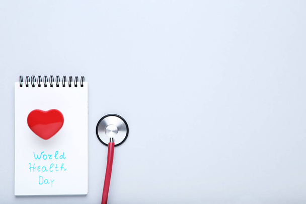 Szöveg egészségügyi világnap a sztetoszkóp és piros szív, a szürke háttér - Fotó, kép