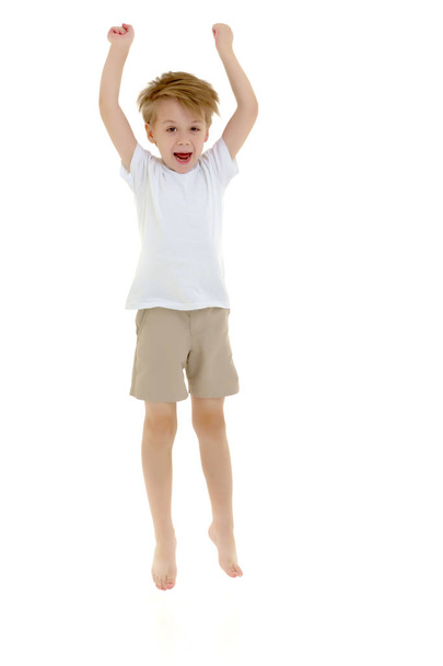 A little boy in a clean white T-shirt is jumping fun. - Фото, зображення