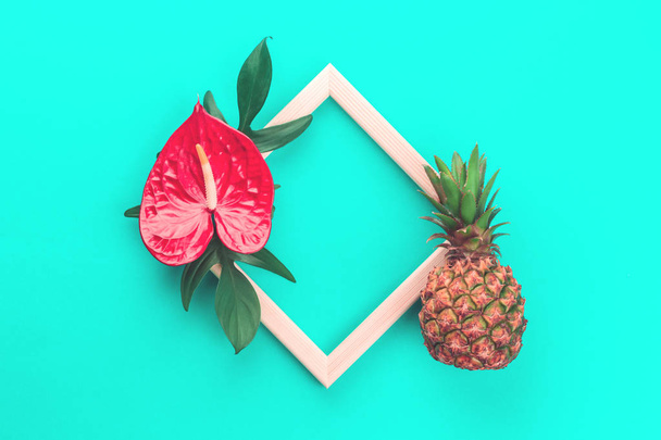 Pineapple, flower and leaves frame on mint background - 写真・画像