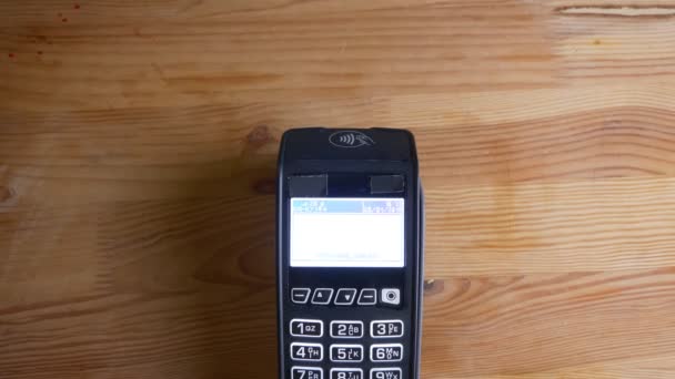 Closeup shoot of a payment terminal being used for payment by an application on the phone with blue screen indoors - Footage, Video