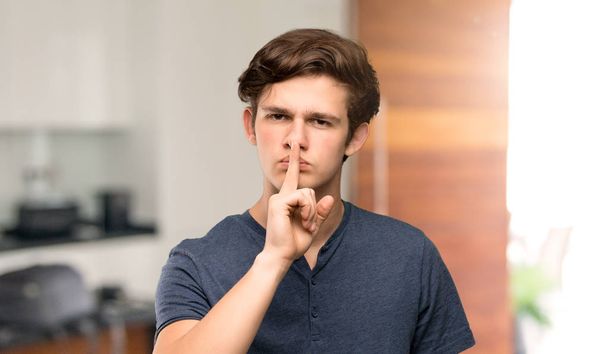 Mężczyzna nastolatek Wyświetlono oznaką gest ciszy, kładąc palec w ustach w pomieszczeniu - Zdjęcie, obraz