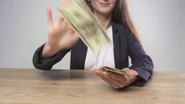 περικομμένη όψη της γυναίκας με επίσημη φθορά τα τραπεζογραμμάτια δολαρίων στην κάμερα και χαμογελαστά απομονωμένα σε γκρι - Πλάνα, βίντεο