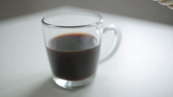 Pouring coffee and milk into a glass mug. Coffee break and office situation. - Filmati, video
