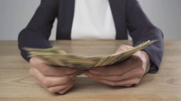 vista recortada de la mujer en ropa formal contando billetes de dólar en la mesa de madera aislada en gris
 - Metraje, vídeo