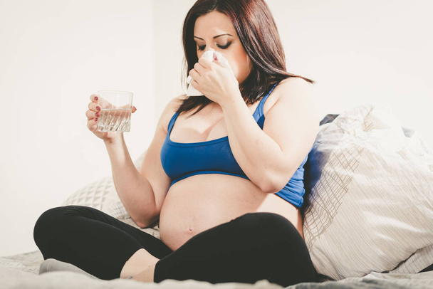 Pregnant woman blowing her nose - Фото, зображення