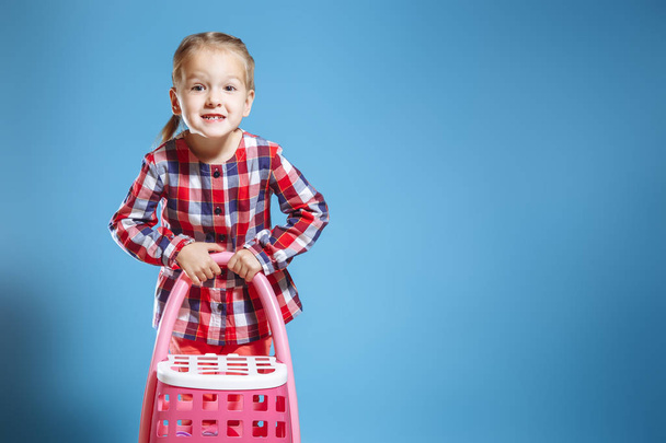 Little cute girl with toy suitcase on blue background. - Fotografie, Obrázek