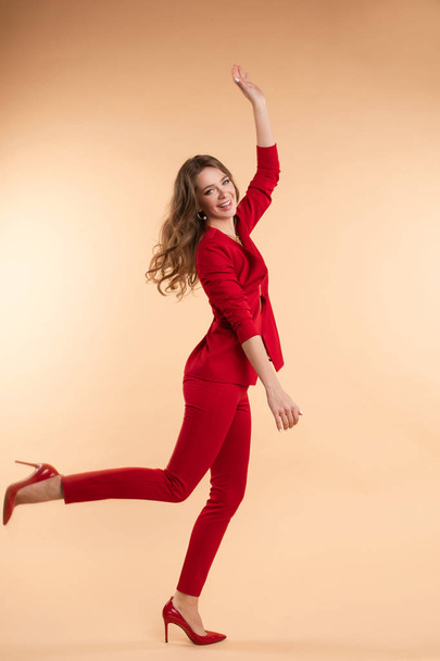 Happy woman in smart suit looking at camera and jumping - Foto, Imagem