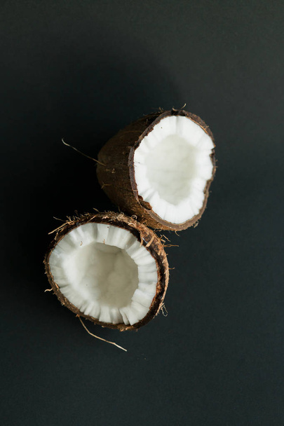 Rozbité kokosové ořechy na černém pozadí. Bílé maso - Fotografie, Obrázek