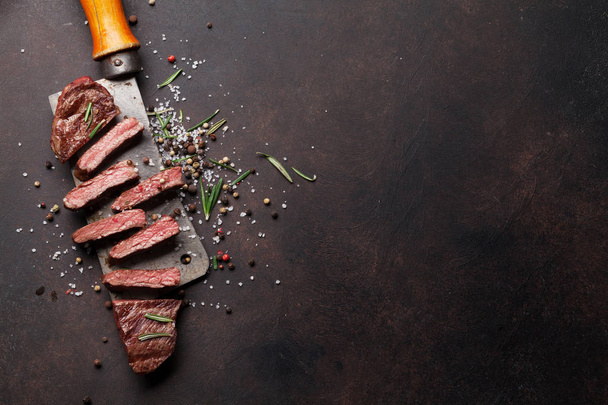Fresh grilled steak over meat butcher knife on stone background - Photo, Image